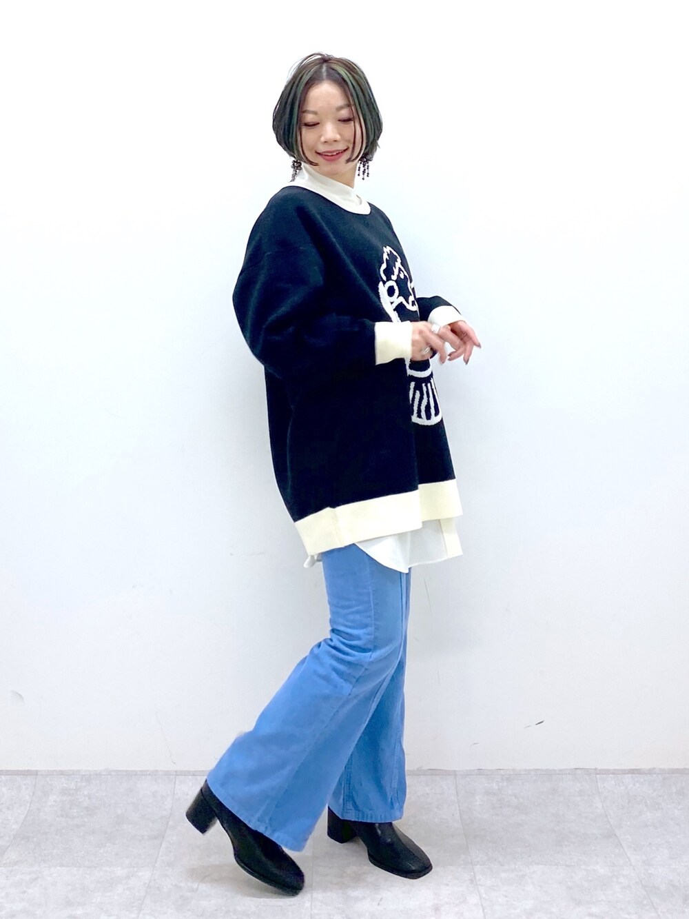 ブラック系のトップス、ホワイト系のトップス、ブルー系のパンツを着用したレディースの秋コーディネートの2枚目の写真