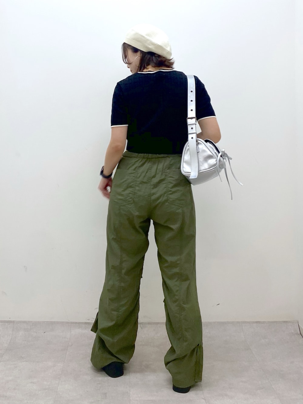 グリーン系のカーゴパンツ、ブラック系のサンダル、シルバー系のショルダーバッグを着用したレディースの夏コーディネートの6枚目の写真