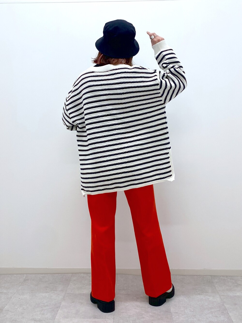 ホワイト系のニット/セーター、レッド系のスラックス、ホワイト系のローファーを着用したレディースの冬コーディネートの4枚目の写真