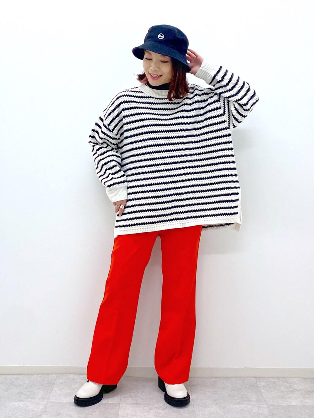 ホワイト系のニット/セーター、レッド系のスラックス、ホワイト系のローファーを着用したレディースの冬コーディネートの2枚目の写真