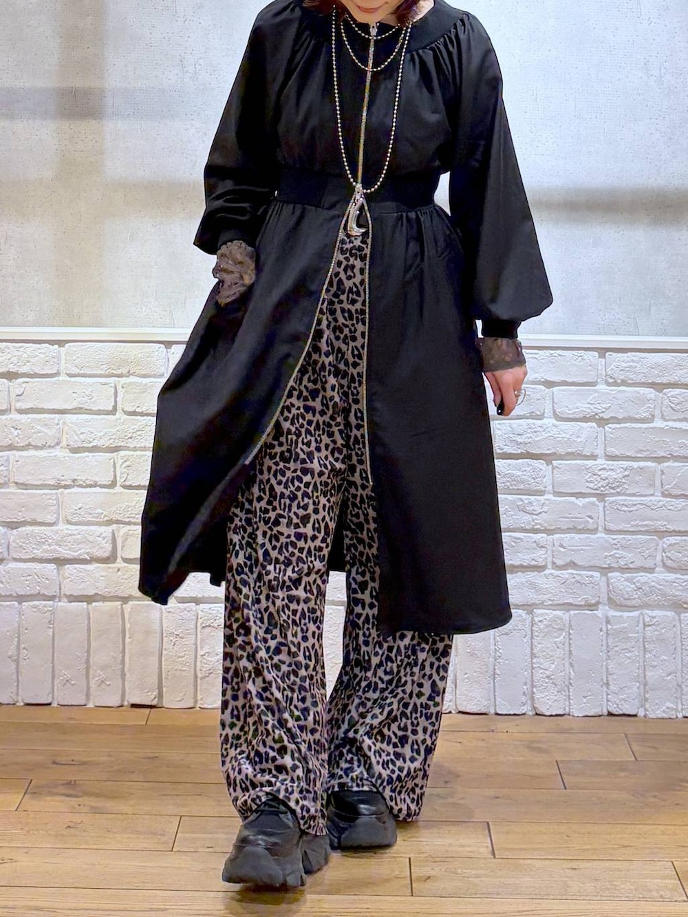 ブラック系のブーツ、ベージュ系のその他パンツ、ブラック系のワンピースを着用したレディースの冬コーディネートの2枚目の写真