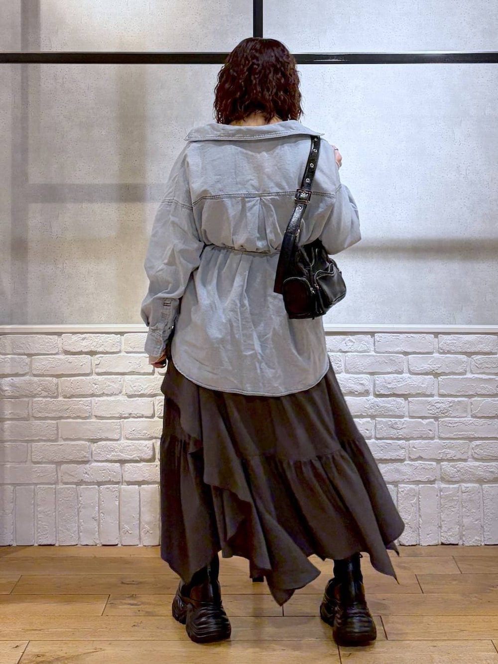 ブラック系のブーツ、ブラック系のショルダーバッグ、グレー系のスカートを着用したレディースの冬コーディネートの6枚目の写真