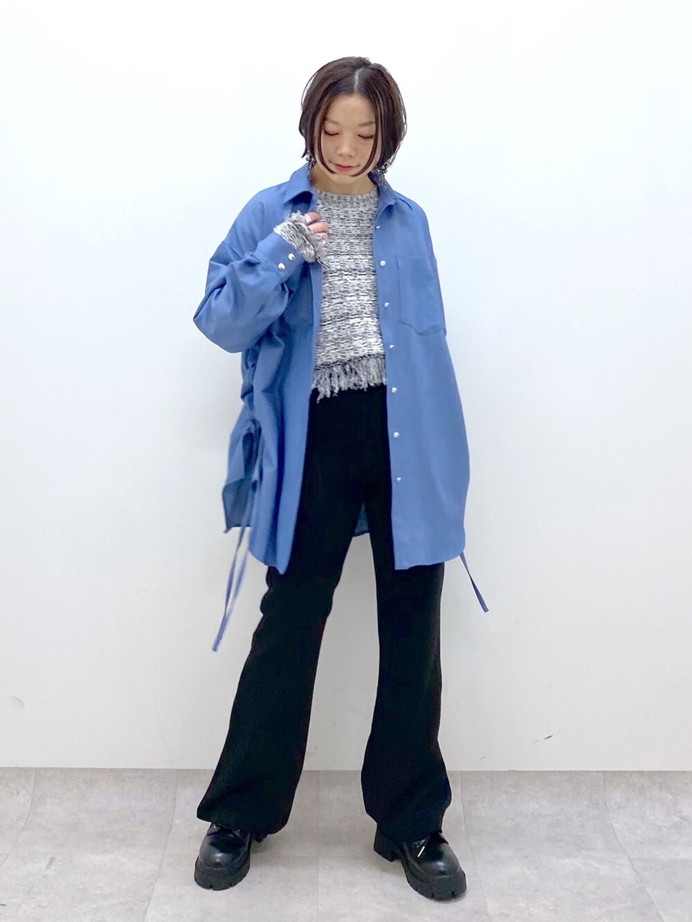 ブラック系のデニムパンツ、ブルー系のシャツ/ブラウス、ホワイト系のニット/セーターを着用したレディースの冬コーディネートの5枚目の写真