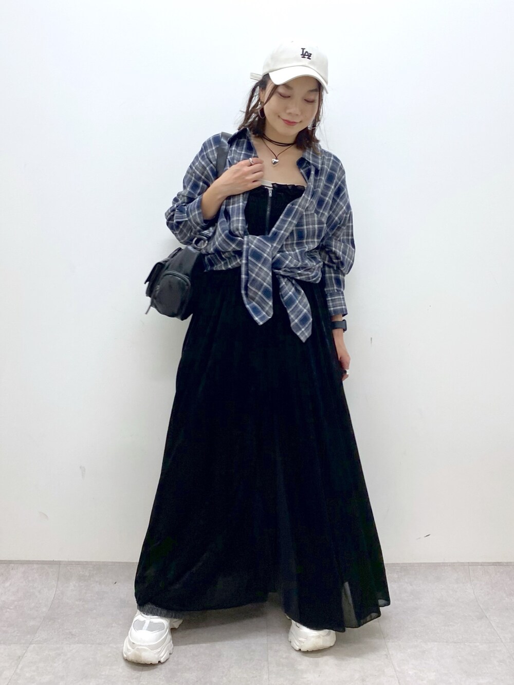 ブラック系のワンピース、ホワイト系のスニーカー、ブラック系のデニムパンツを着用したレディースの夏コーディネートの8枚目の写真
