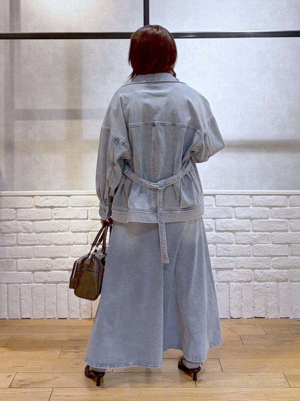 ブルー系のブルゾン、グレー系のショルダーバッグ、ホワイト系のニット/セーターを着用したレディースの春コーディネートの6枚目の写真