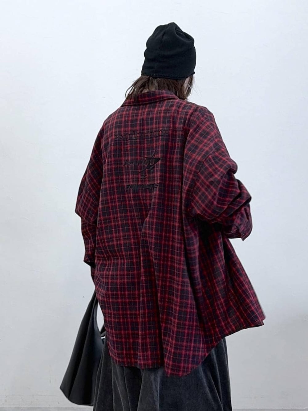 ブラック系のスニーカー、ブラック系のデニムスカート、ブラック系のトートバッグを着用したレディースの春コーディネートの2枚目の写真