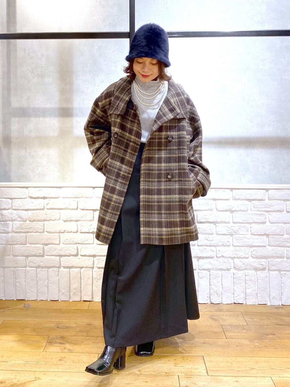 ブラウン系のテーラードジャケット、グレー系のTシャツ/カットソー、ブラック系のスカートを着用したレディースの冬コーディネートの8枚目の写真