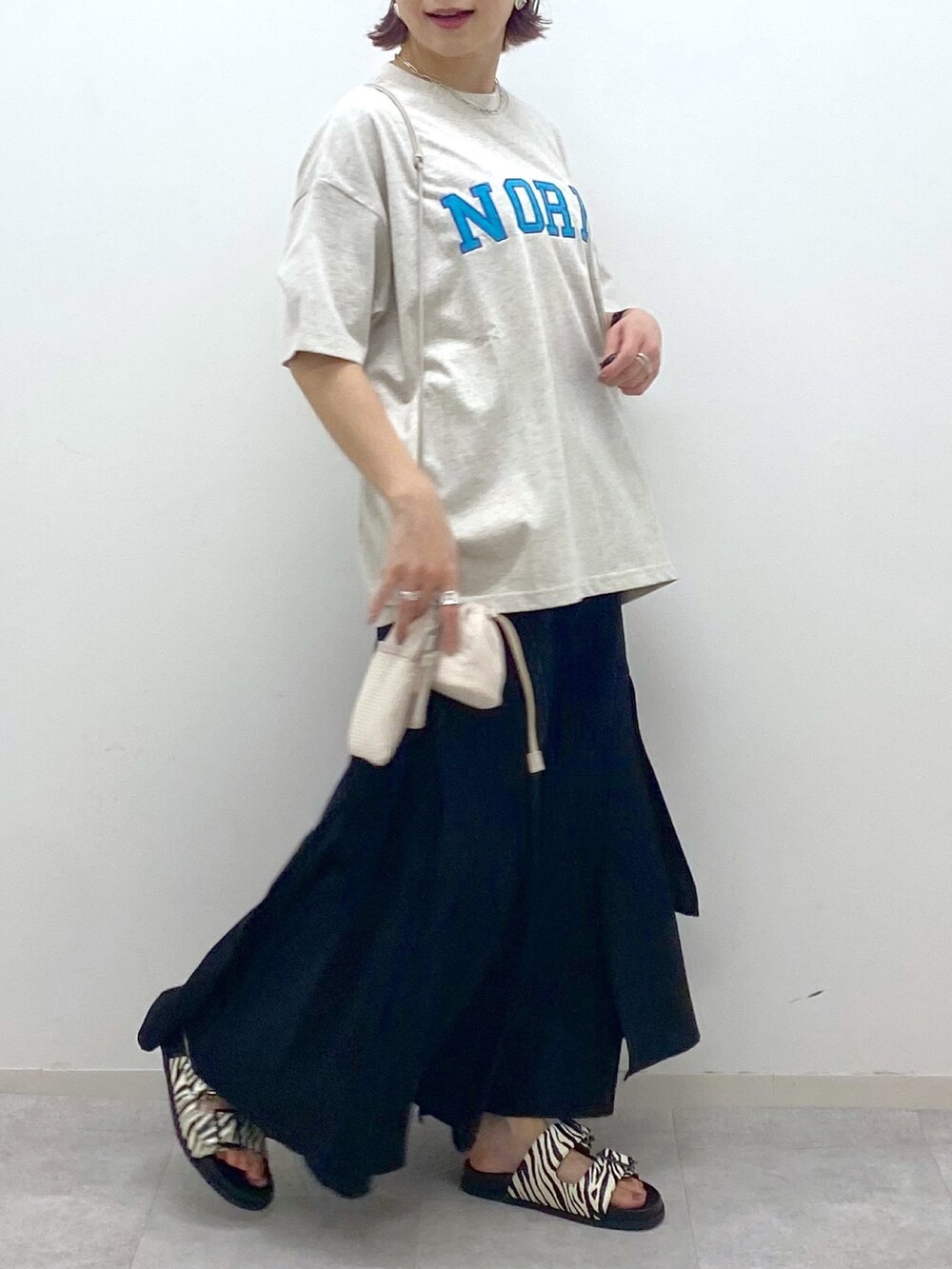 ベージュ系のTシャツ/カットソー、ブラック系のスカート、その他のサンダルを着用したレディースの夏コーディネートの5枚目の写真