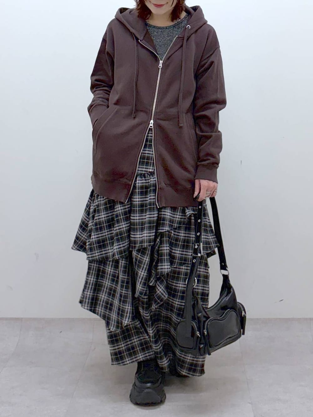 ブラック系のブーツ、シルバー系のTシャツ/カットソー、ブラウン系のパーカーを着用したレディースの冬コーディネートの3枚目の写真