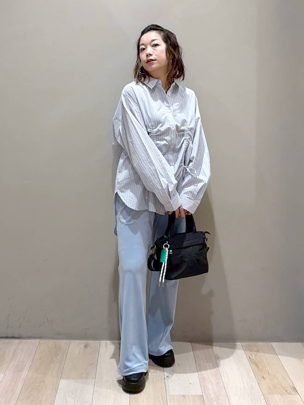 ブルー系のシャツ/ブラウス、ブラック系のブーツ、ブルー系のその他パンツを着用したレディースの秋コーディネートの9枚目の写真
