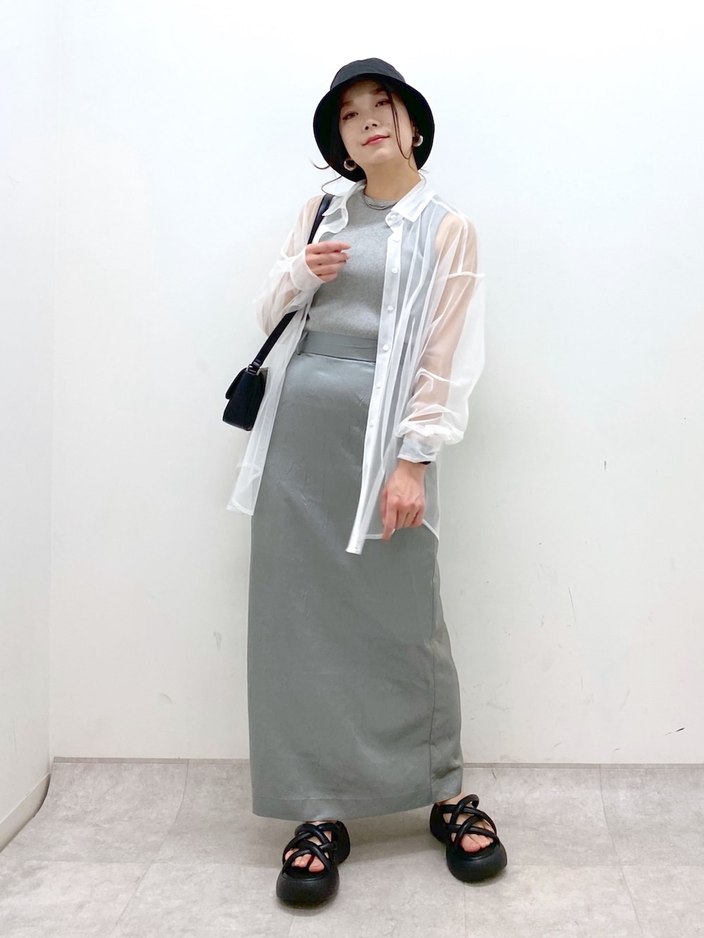 ブルー系のスカート、ブラック系のハンドバッグ、ブラック系のサンダルを着用したレディースの春コーディネートの9枚目の写真