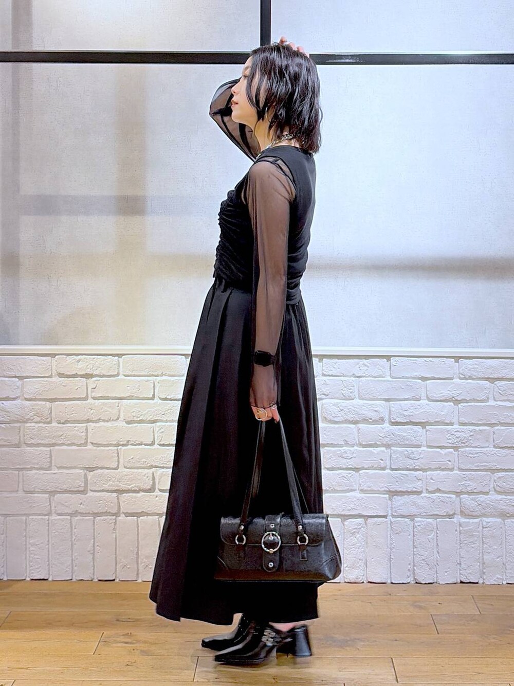 ブラック系のTシャツ/カットソー、ブラック系のショルダーバッグ、ブラック系のサンダルを着用したレディースの夏コーディネートの5枚目の写真