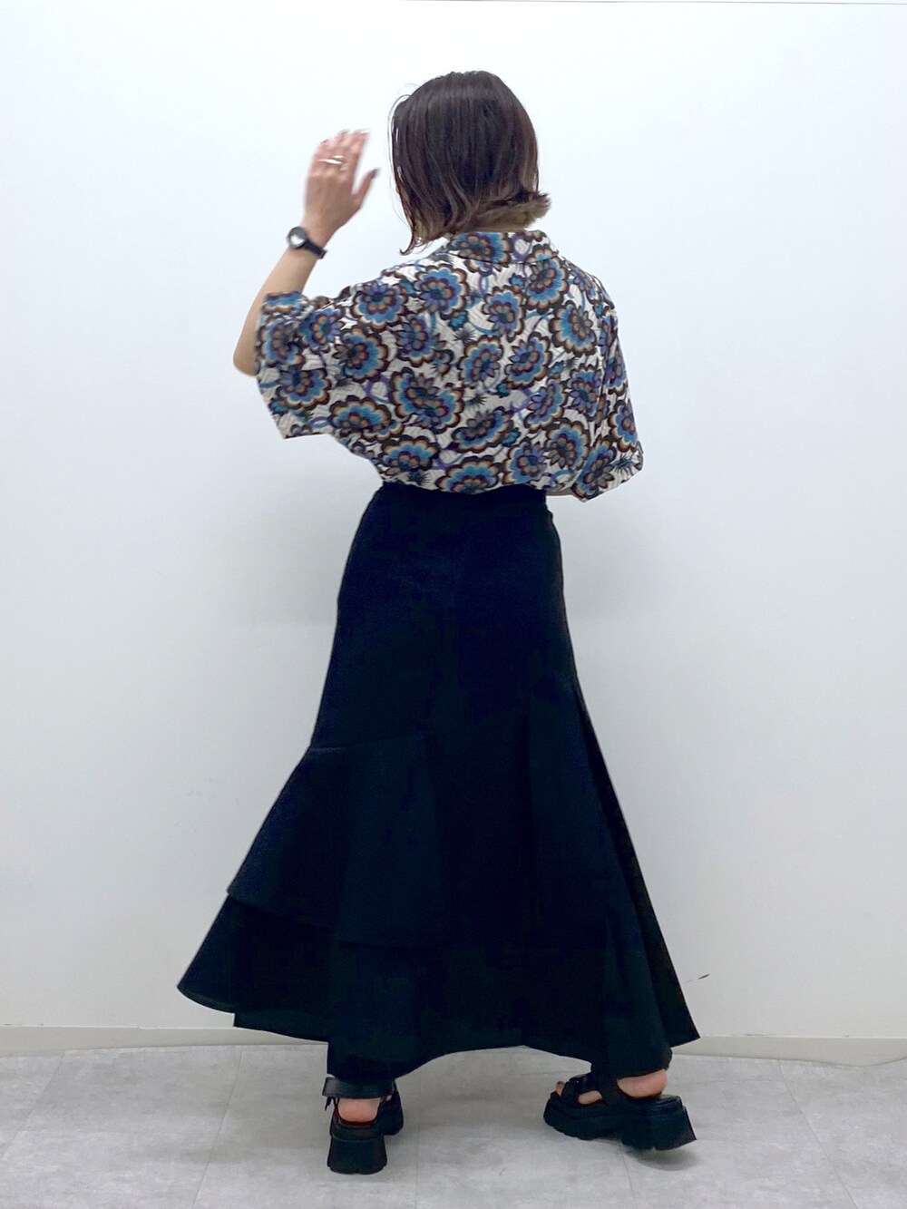 ホワイト系のシャツ/ブラウス、ブラック系のスカート、ブラック系のサンダルを着用したレディースの春コーディネートの3枚目の写真