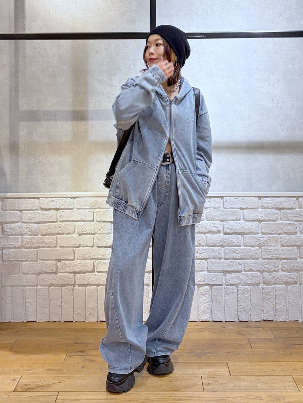 ブラック系のスニーカー、ブラック系のショルダーバッグ、ブルー系のパーカーを着用したレディースの春コーディネートの8枚目の写真