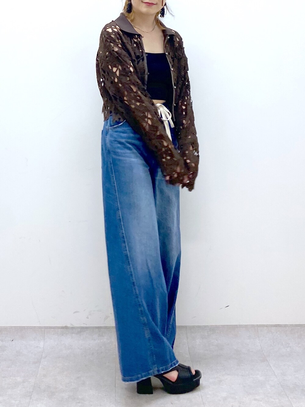 ブルー系のデニムパンツ、ブラウン系のカーディガン/ボレロ、ブラック系のキャミソールを着用したレディースの夏コーディネートの7枚目の写真