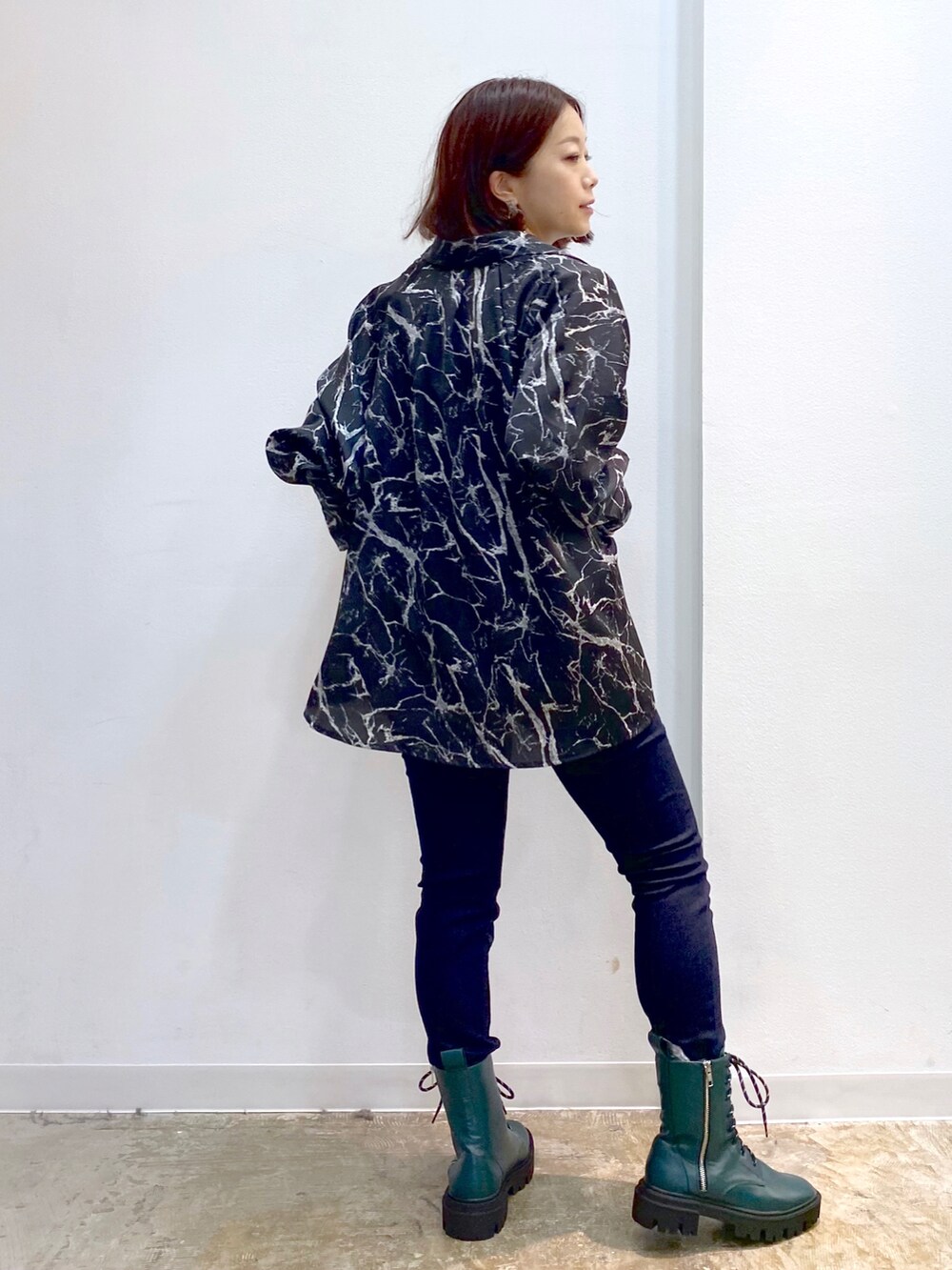 ブラック系のシャツ/ブラウス、グレー系のニット/セーター、グリーン系のブーツを着用したレディースの秋コーディネートの3枚目の写真