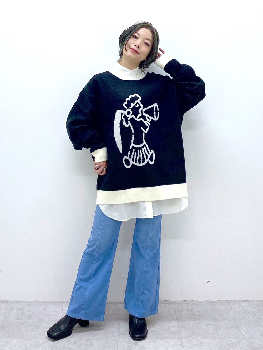 ブラック系のトップス、ホワイト系のトップス、ブルー系のパンツを着用したレディースの秋コーディネートの5枚目の写真