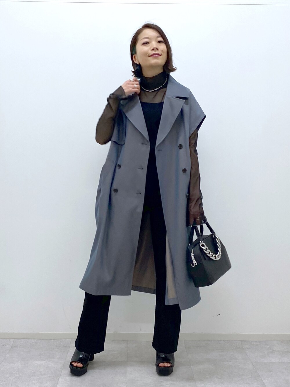 ブラック系のショルダーバッグ、ブラック系のデニムパンツ、ベージュ系のその他アウターを着用したレディースの春コーディネートの5枚目の写真