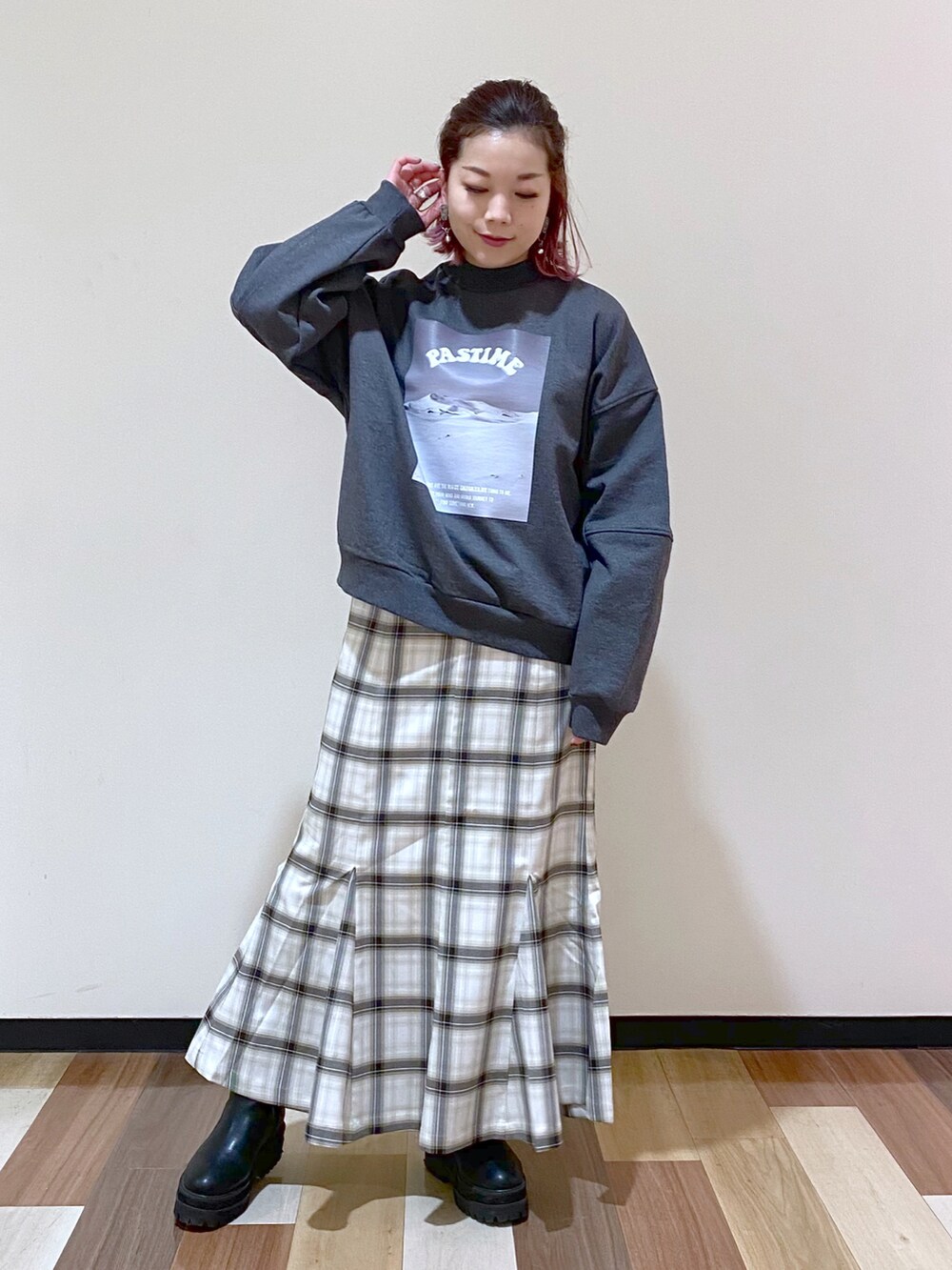 グレー系のスウェット、ホワイト系のスカート、ブラック系のブーツを着用したレディースの冬コーディネートの2枚目の写真