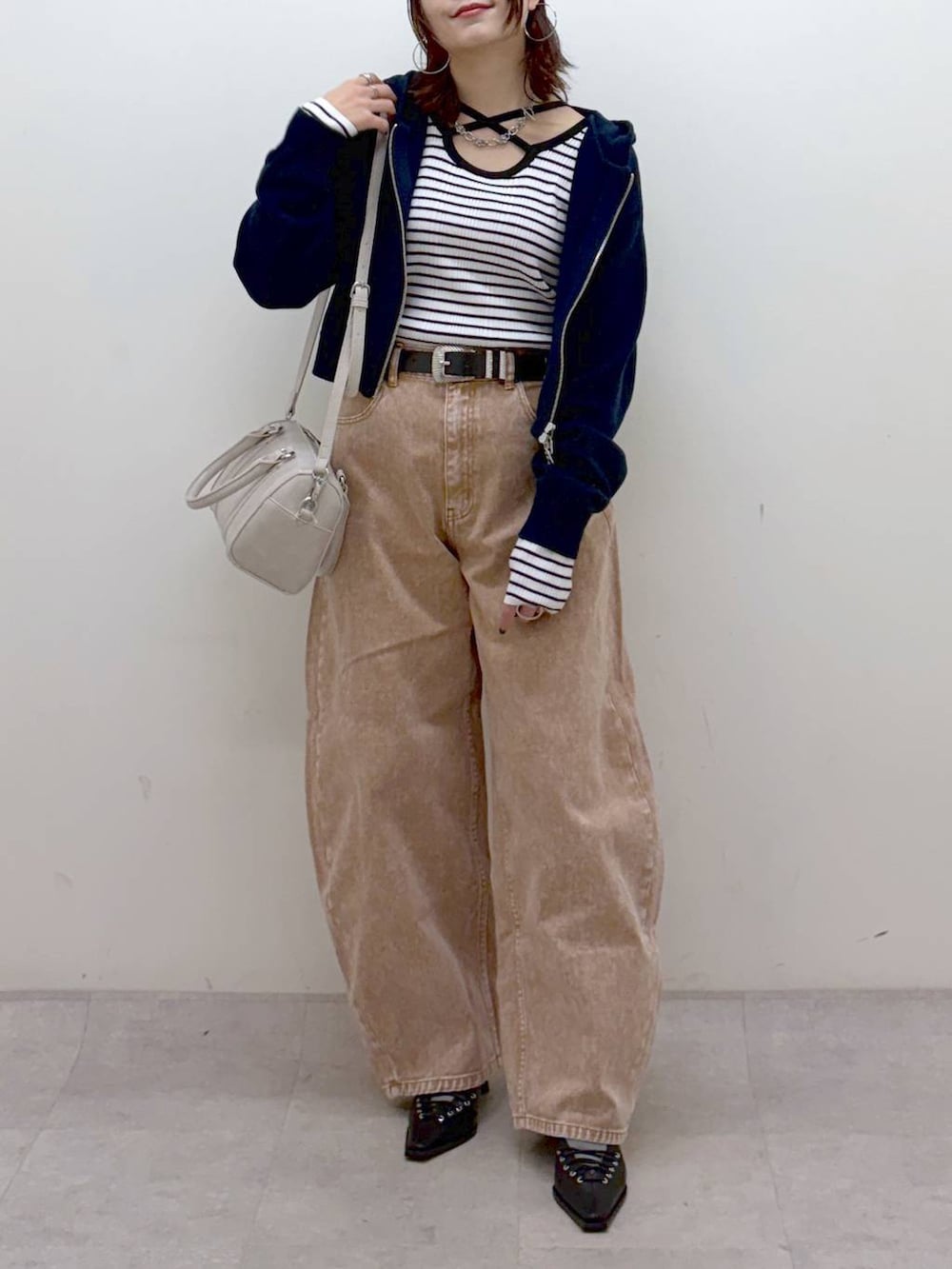 ブラウン系のデニムパンツ、ブラウン系のデニムパンツ、ホワイト系のボストンバッグを着用したレディースの冬コーディネートの2枚目の写真