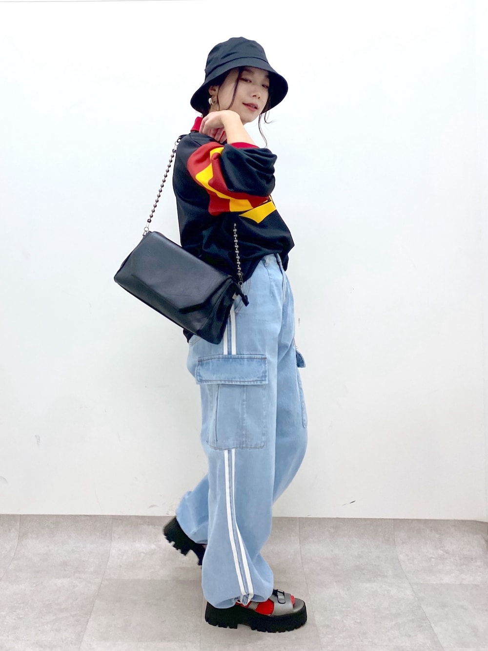 ブラック系のシャツ/ブラウス、ブルー系のデニムパンツ、ブラック系のショルダーバッグを着用したレディースの春コーディネートの4枚目の写真