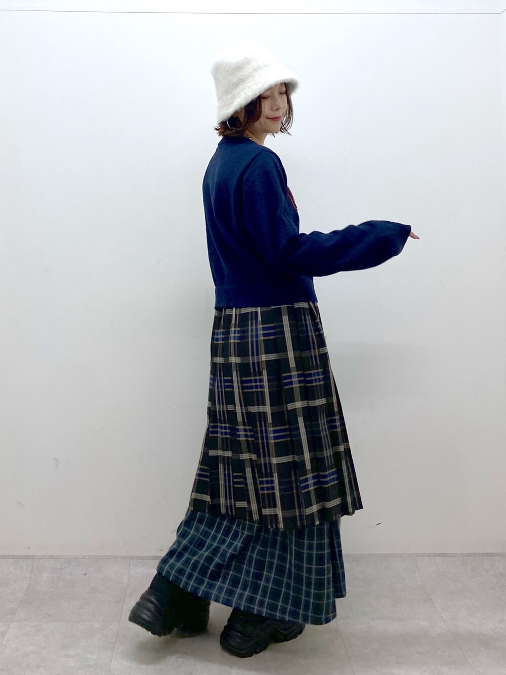 ブルー系のニット/セーター、ブルー系のスカート、ブラック系のショルダーバッグを着用したレディースの秋コーディネートの5枚目の写真