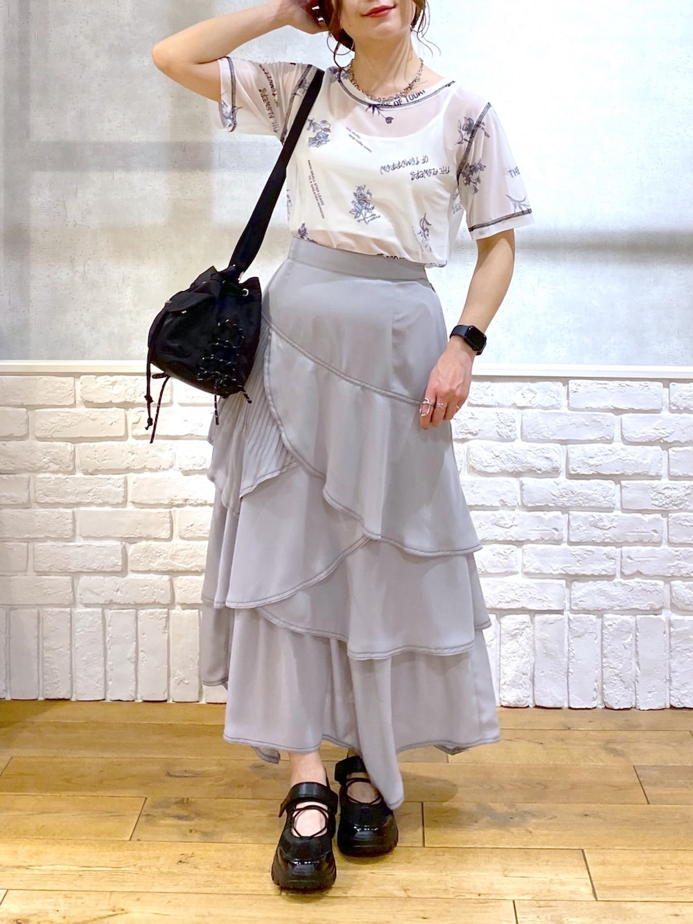 ブラック系のデニムジャケット、グレー系のスカート、ブラック系のスニーカーを着用したレディースの春コーディネートの3枚目の写真