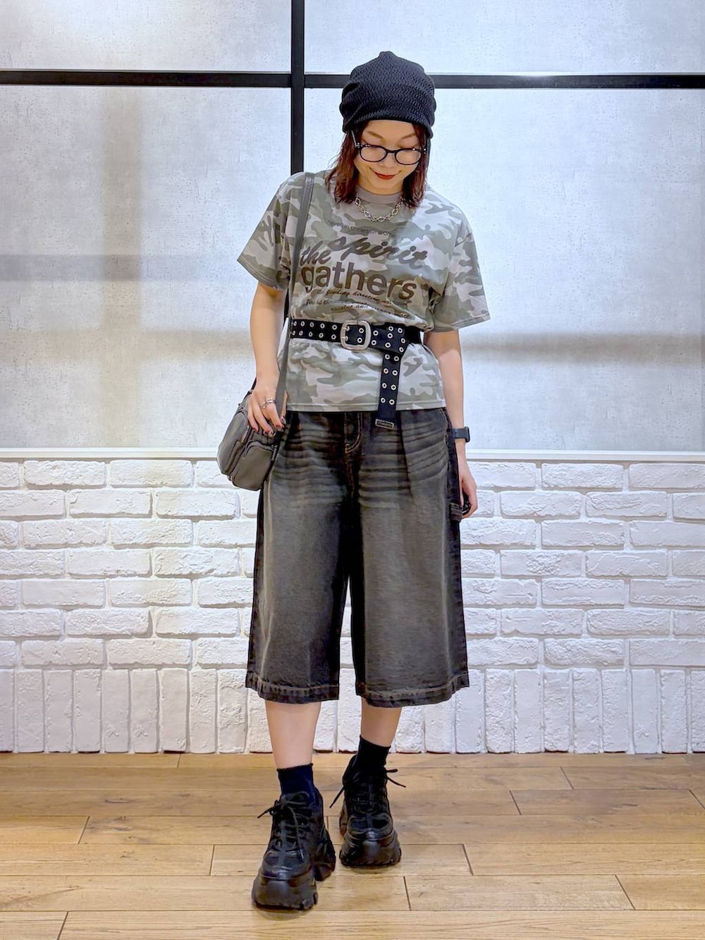 ブラック系のスニーカー、ブラック系のデニムパンツ、グレー系のショルダーバッグを着用したレディースの春コーディネートの6枚目の写真