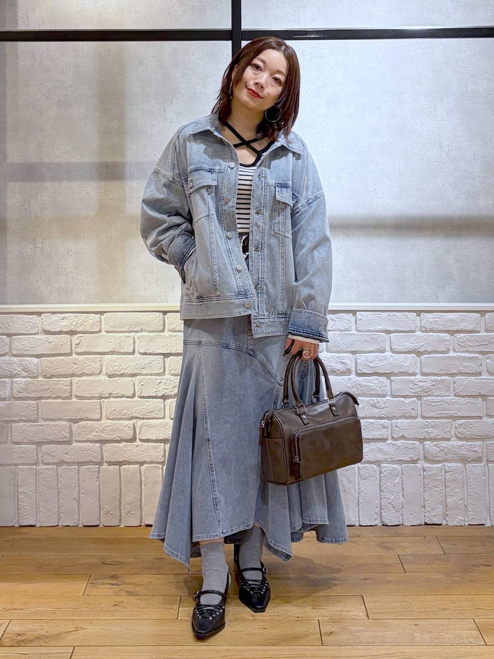 ブルー系のブルゾン、グレー系のショルダーバッグ、ホワイト系のニット/セーターを着用したレディースの春コーディネートの4枚目の写真