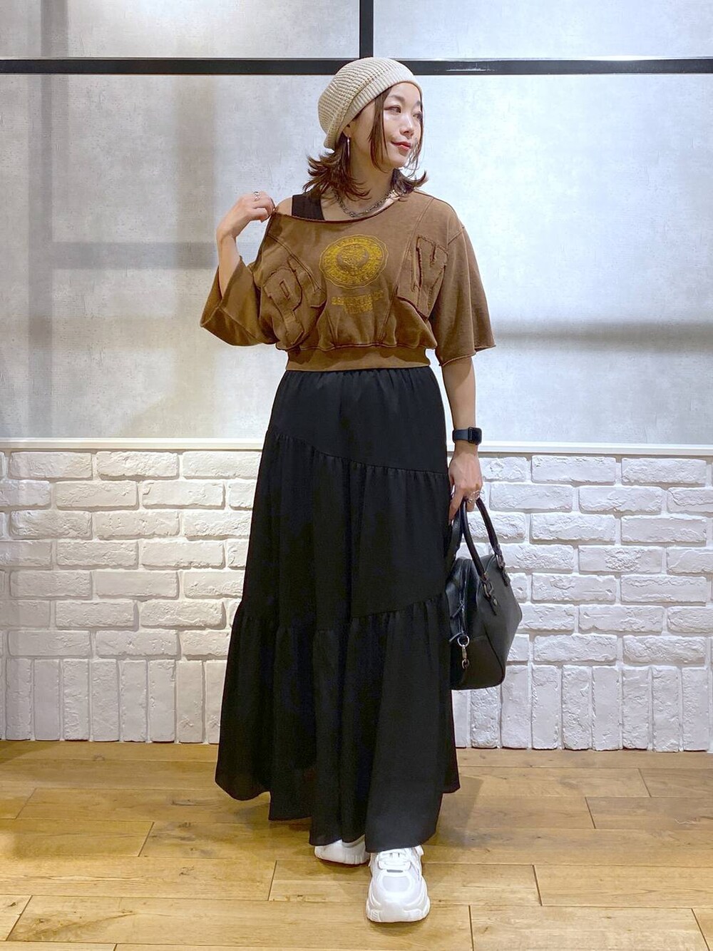 ブラウン系のタンクトップ、ブラック系のショルダーバッグ、ホワイト系のスニーカーを着用したレディースの夏コーディネートの9枚目の写真