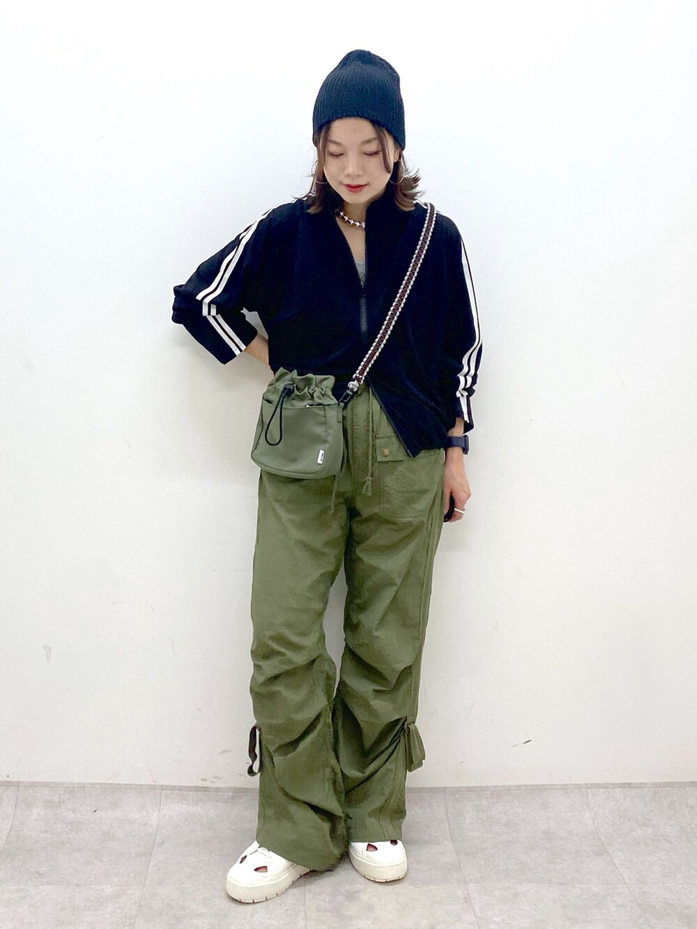 グリーン系のカーゴパンツ、ホワイト系のスニーカー、グリーン系のショルダーバッグを着用したレディースの夏コーディネートの9枚目の写真