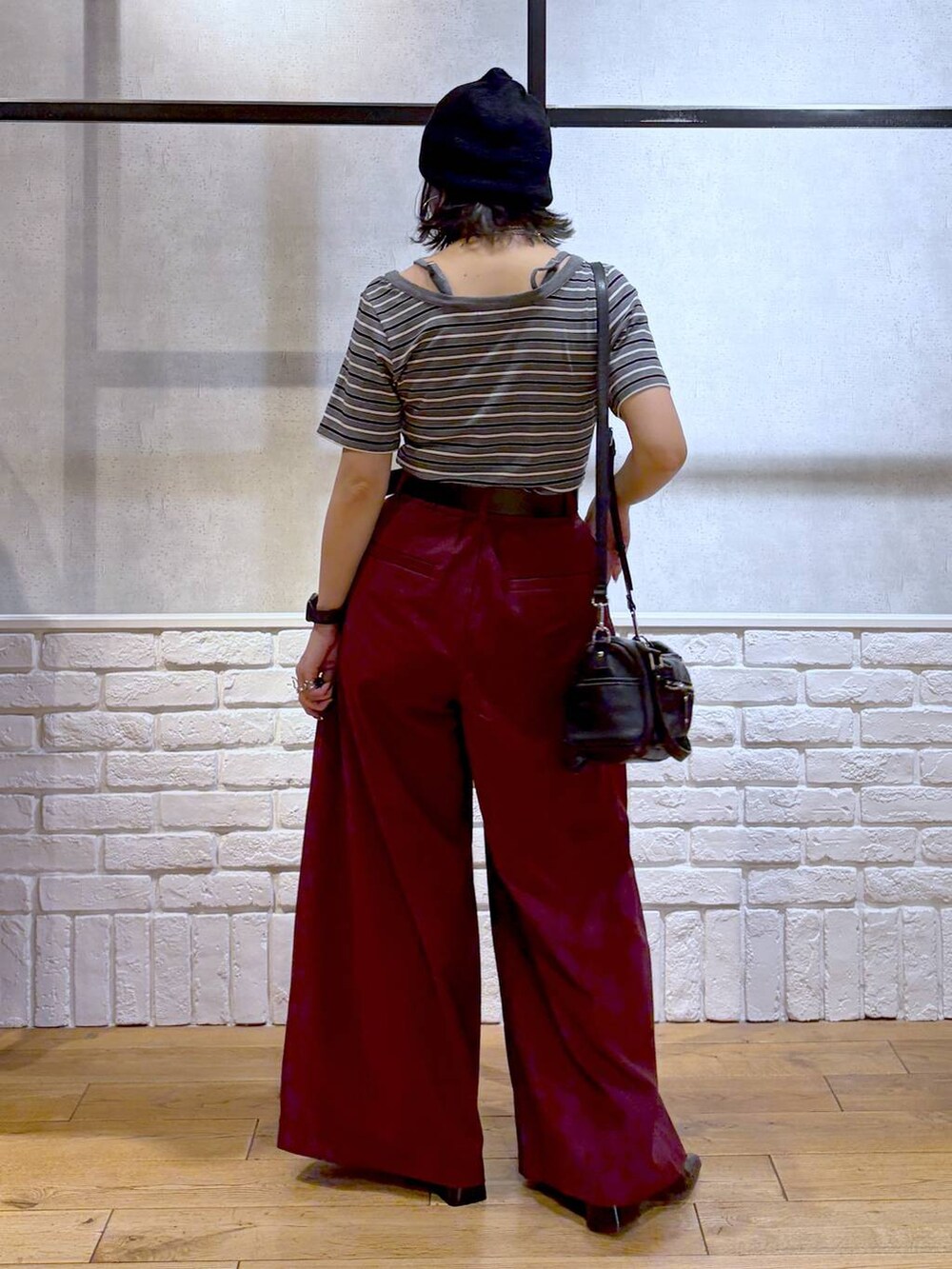 ブラック系のショルダーバッグ、レッド系のスラックス、グレー系のTシャツ/カットソーを着用したレディースの夏コーディネートの6枚目の写真