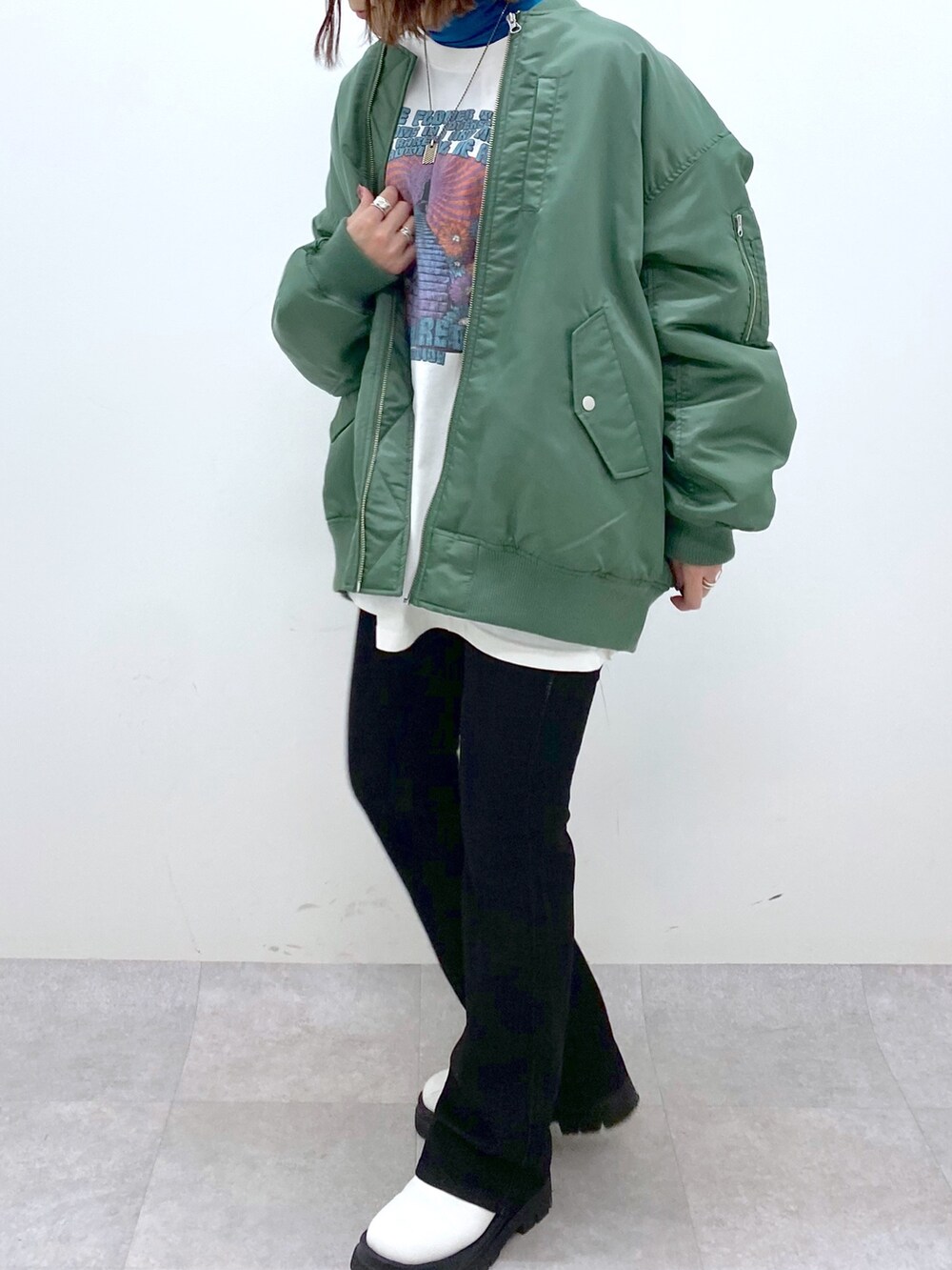 ブラック系のデニムパンツ、ホワイト系のシューズ、ブルー系のTシャツ/カットソーを着用したレディースの秋コーディネートの4枚目の写真