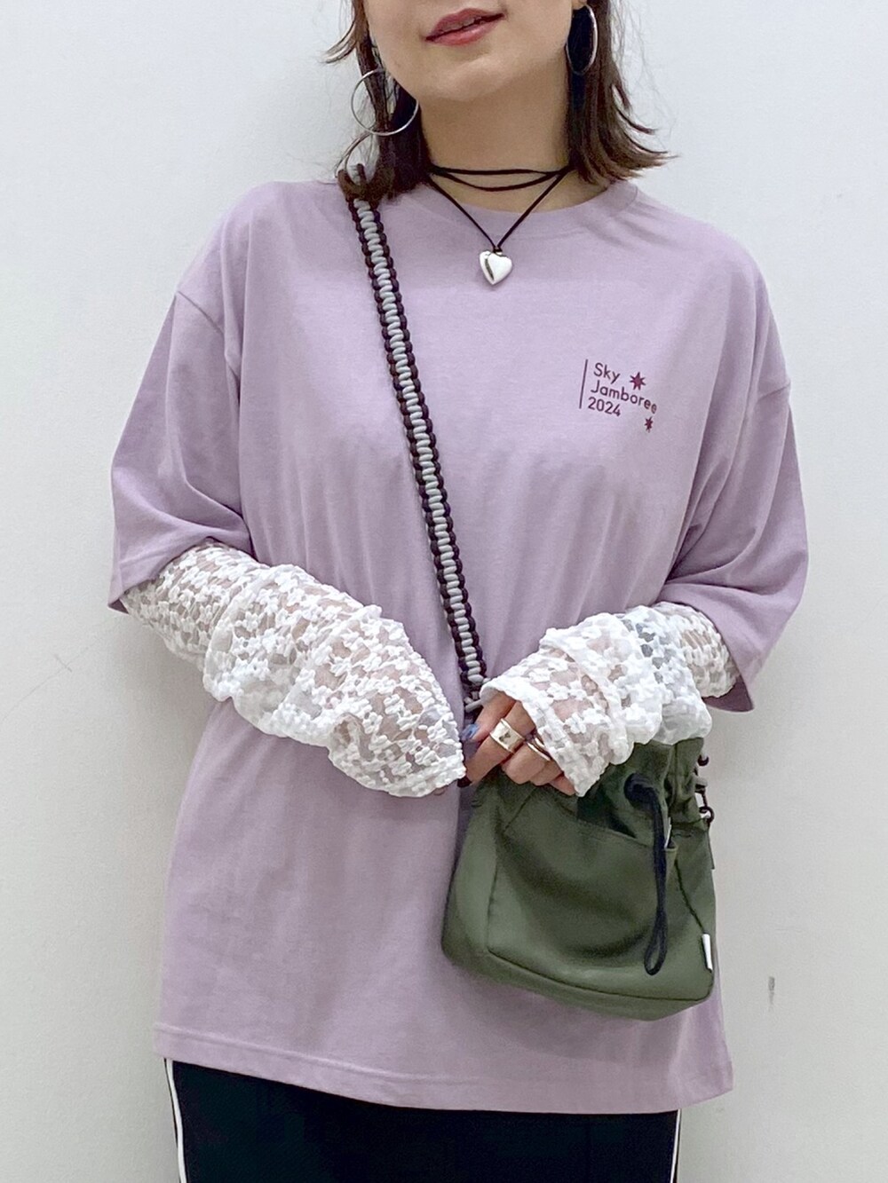 ブラック系のスカート、ホワイト系のスニーカー、ホワイト系のTシャツ/カットソーを着用したレディースの夏コーディネートの2枚目の写真