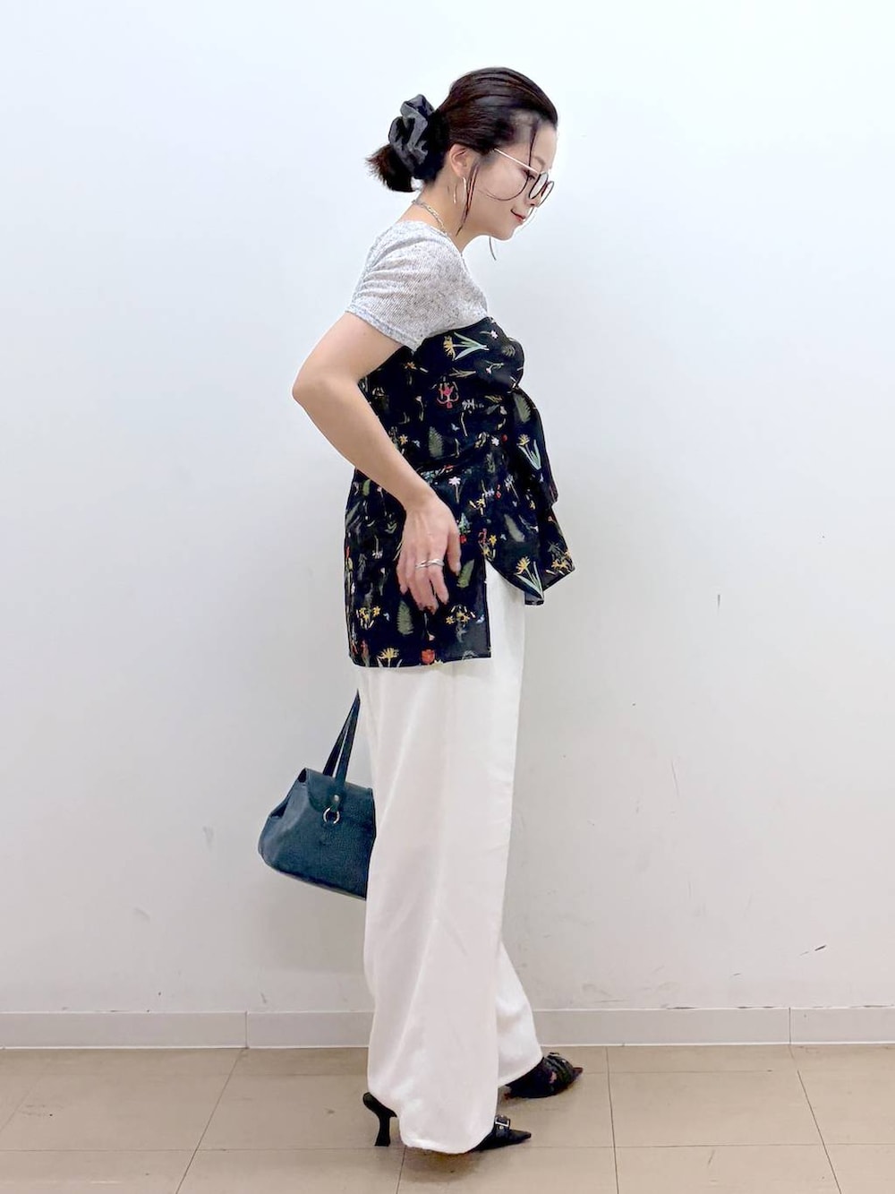 ホワイト系のスラックス、ブラック系のサンダル、グレー系のTシャツ/カットソーを着用したレディースの夏コーディネートの7枚目の写真