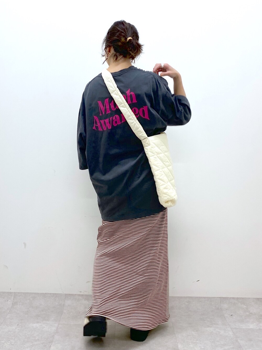 ブラウン系のワンピース、グレー系のTシャツ/カットソー、ホワイト系のショルダーバッグを着用したレディースの春コーディネートの4枚目の写真