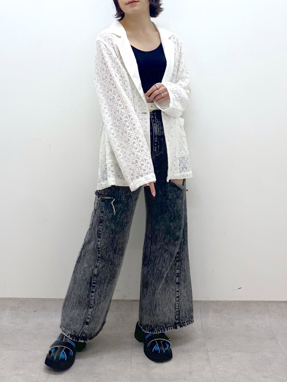 ホワイト系のテーラードジャケット、ブラック系のパンツ、ブラック系のサンダルを着用したレディースの春コーディネートの5枚目の写真