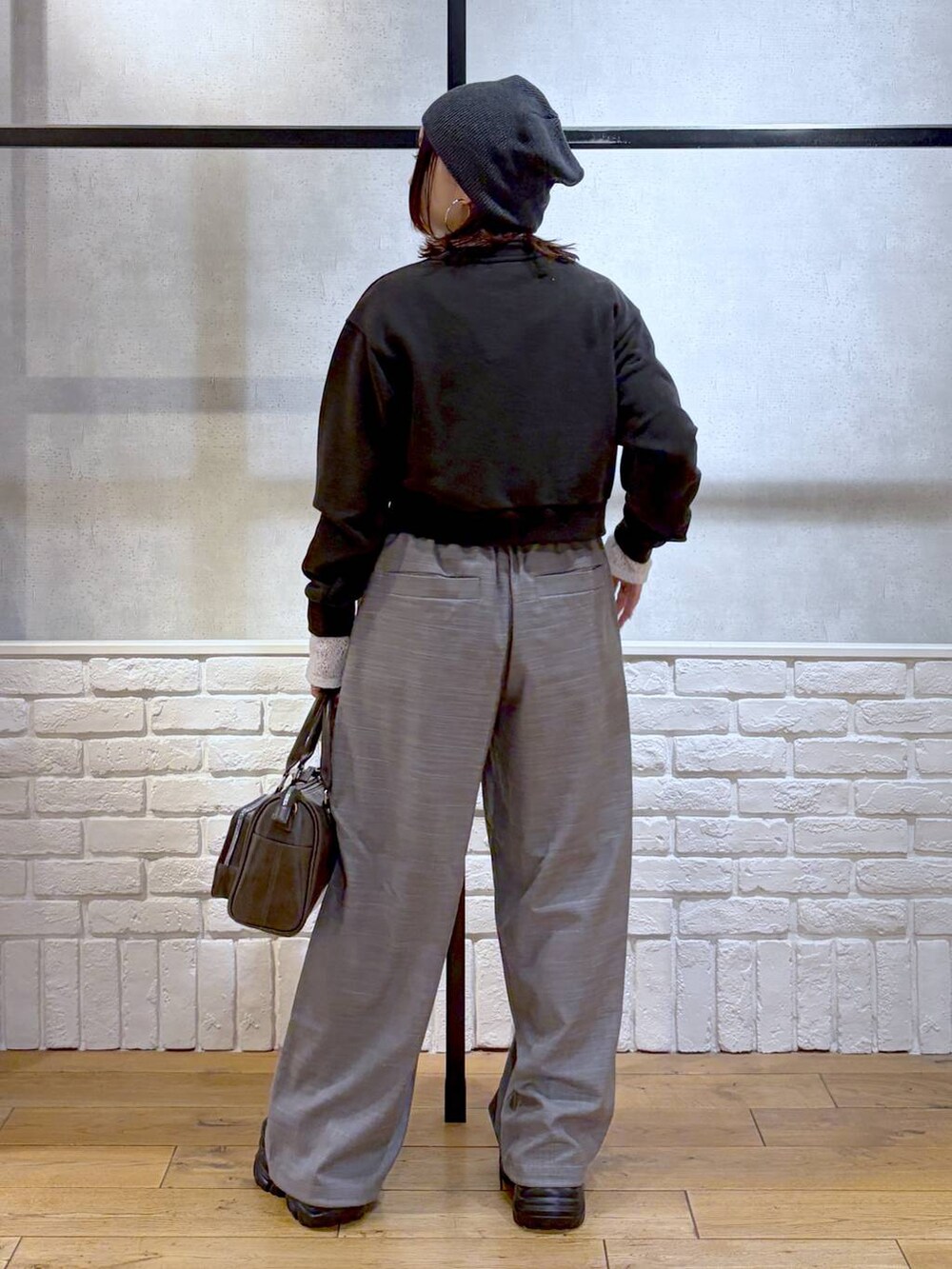 ブラック系のスニーカー、グレー系のスウェット、ブラック系のショルダーバッグを着用したレディースの冬コーディネートの6枚目の写真