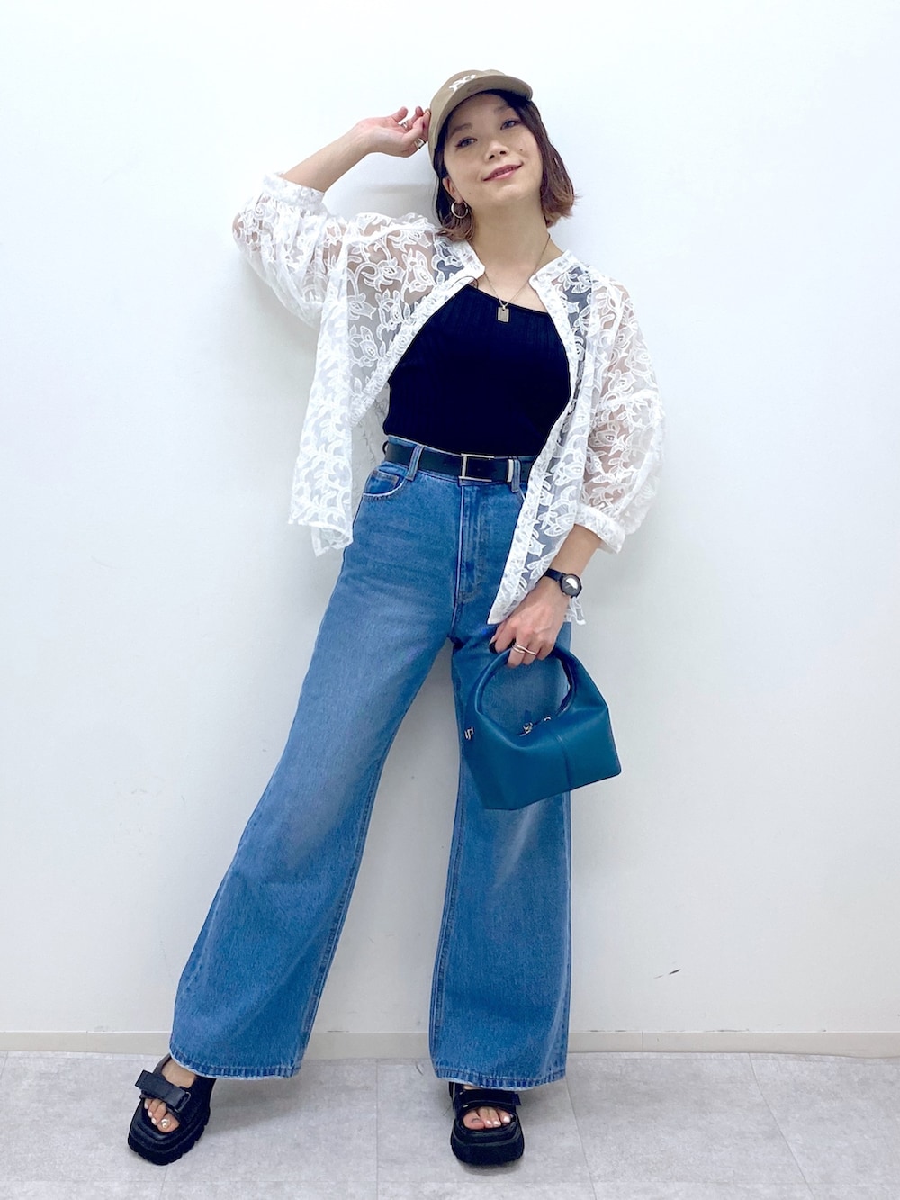 ブルー系のパンツ、ブラック系のサンダル、ブルー系のショルダーバッグを着用したレディースの夏コーディネートの2枚目の写真