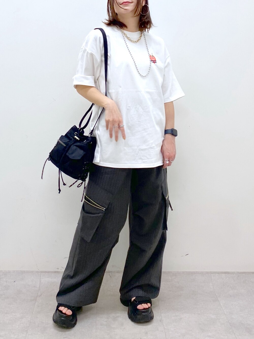ホワイト系のTシャツ/カットソー、ブラック系のボディバッグ/ウエストポーチ、グレー系のカーゴパンツを着用したレディースの春コーディネートの3枚目の写真