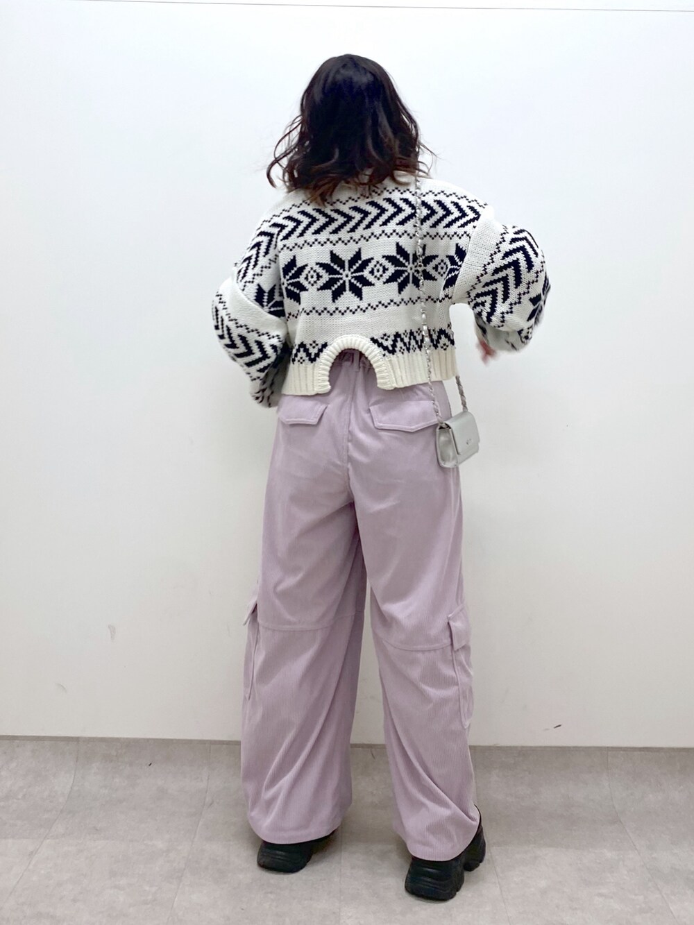 ピンク系のカーゴパンツ、ホワイト系のニット/セーター、シルバー系のショルダーバッグを着用したレディースの冬コーディネートの5枚目の写真