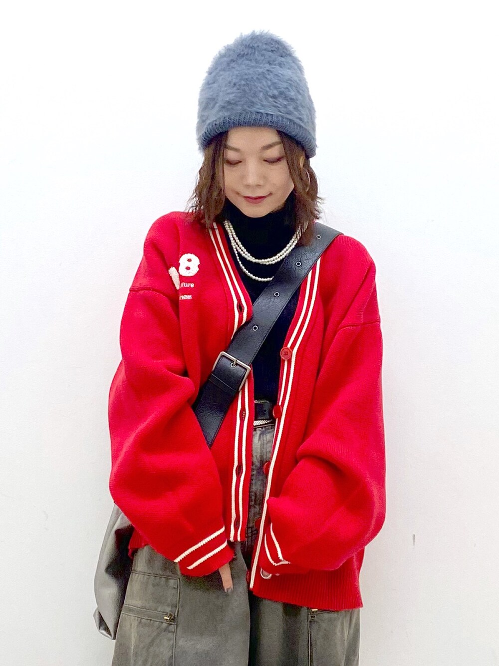 ブラック系のデニムパンツ、ブラック系のブーツ、シルバー系のトートバッグを着用したレディースの秋コーディネートの2枚目の写真