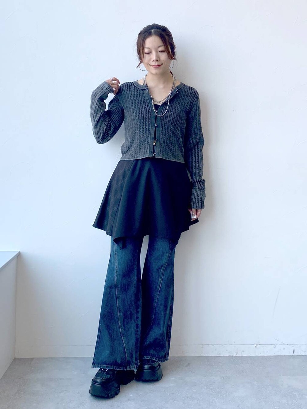 ブラック系のスニーカー、ブルー系のデニムパンツ、ブラック系のスカートを着用したレディースの夏コーディネートの4枚目の写真