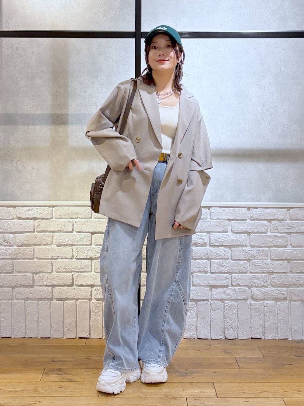 ホワイト系のスニーカー、ホワイト系のタンクトップ、ブラウン系のショルダーバッグを着用したレディースの春コーディネートの9枚目の写真