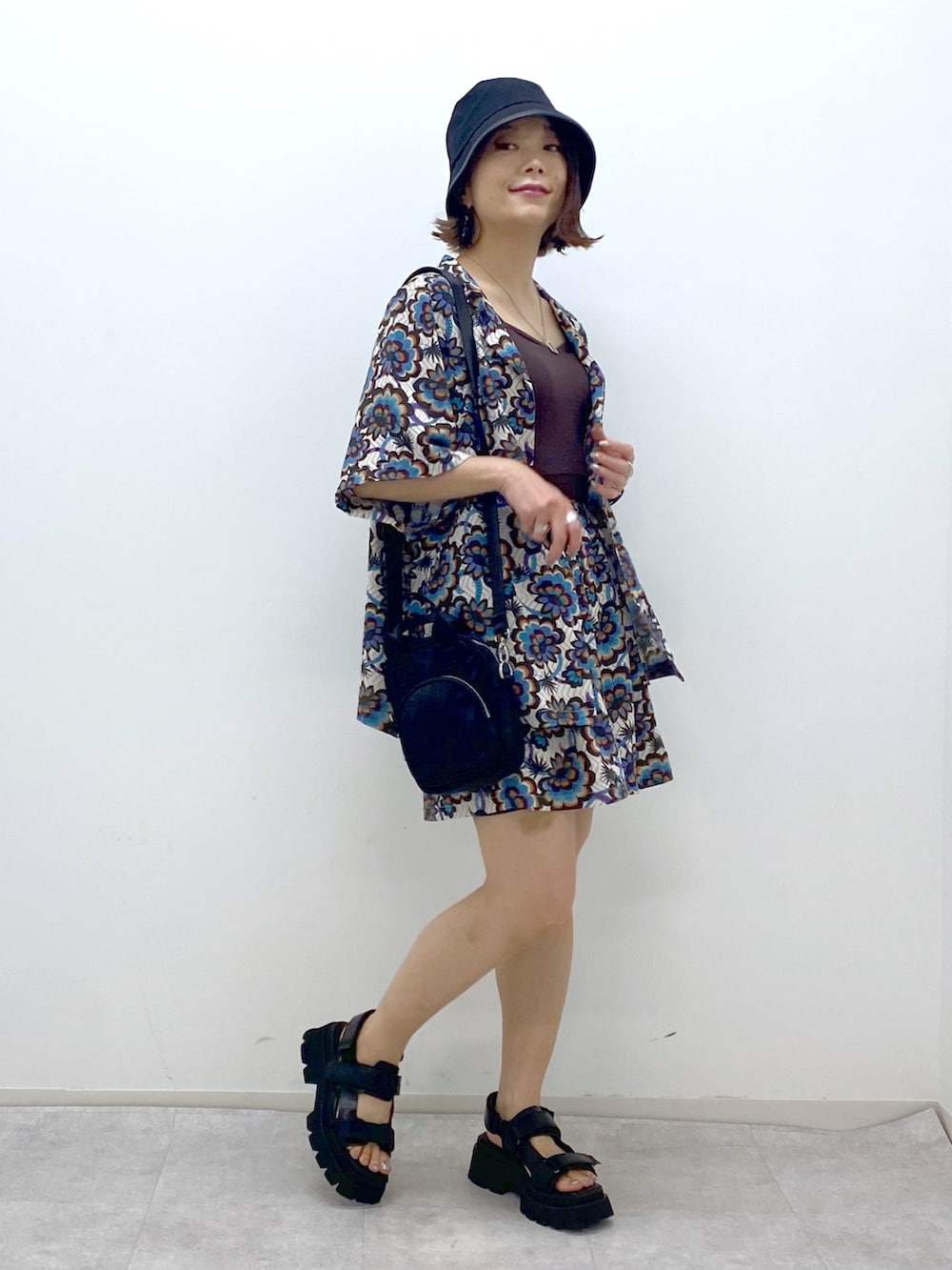 ブラウン系のタンクトップ、ホワイト系のシャツ/ブラウス、ブラック系のショルダーバッグを着用したレディースの春コーディネートの2枚目の写真