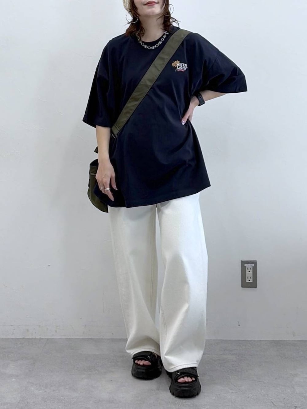 グリーン系のボストンバッグ、ホワイト系のスラックス、ブルー系のTシャツ/カットソーを着用したレディースの春コーディネートの3枚目の写真