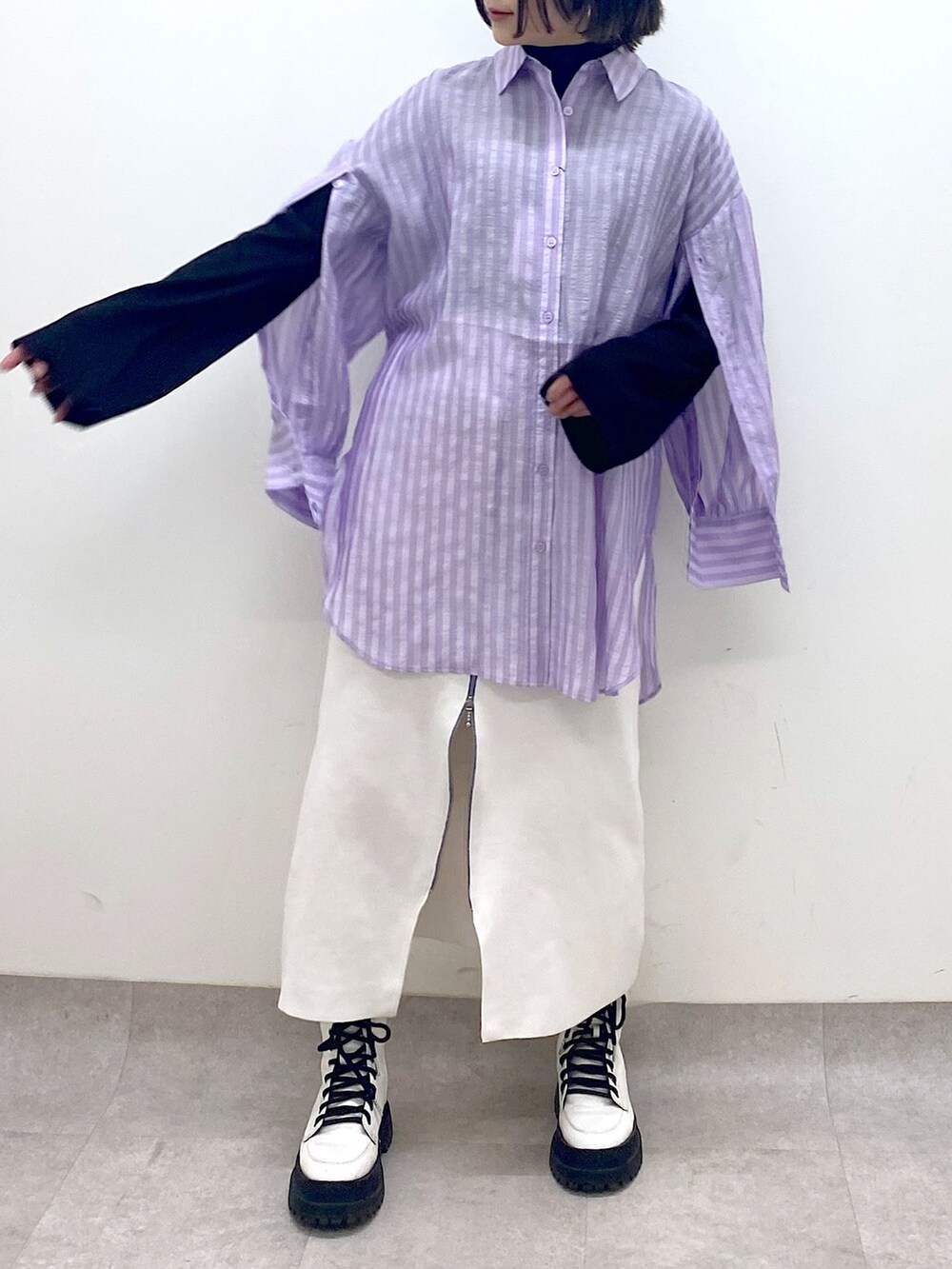 パープル系のトップス、ホワイト系のスカート、ホワイト系のシューズを着用したレディースの春コーディネートの5枚目の写真