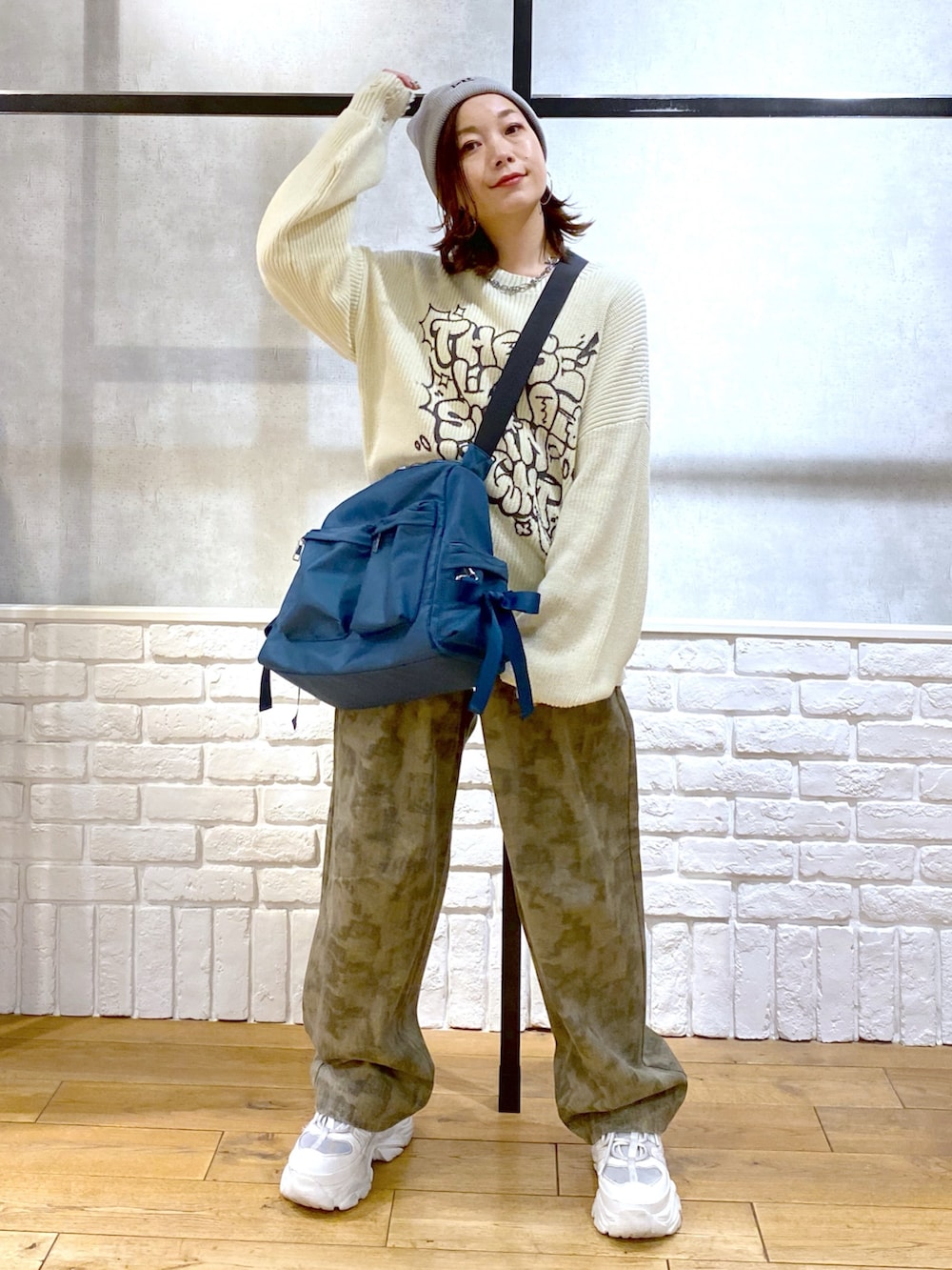 ホワイト系のニット/セーター、ブルー系のショルダーバッグ、その他のデニムパンツを着用したレディースの春コーディネートの4枚目の写真
