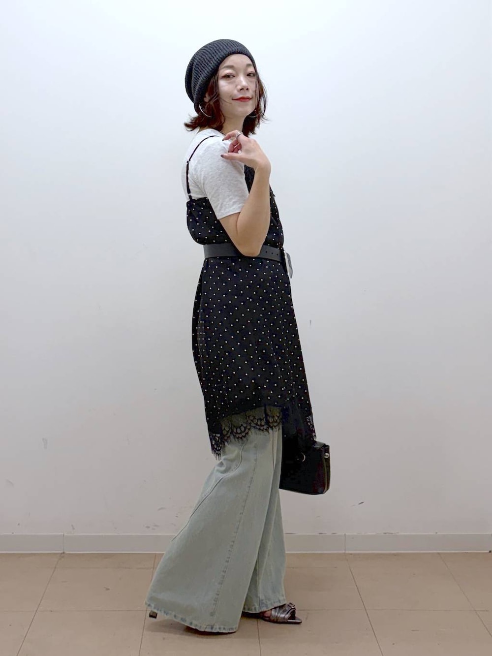 ブラック系のチュニック、ブルー系のデニムパンツ、その他のサンダルを着用したレディースの夏コーディネートの5枚目の写真
