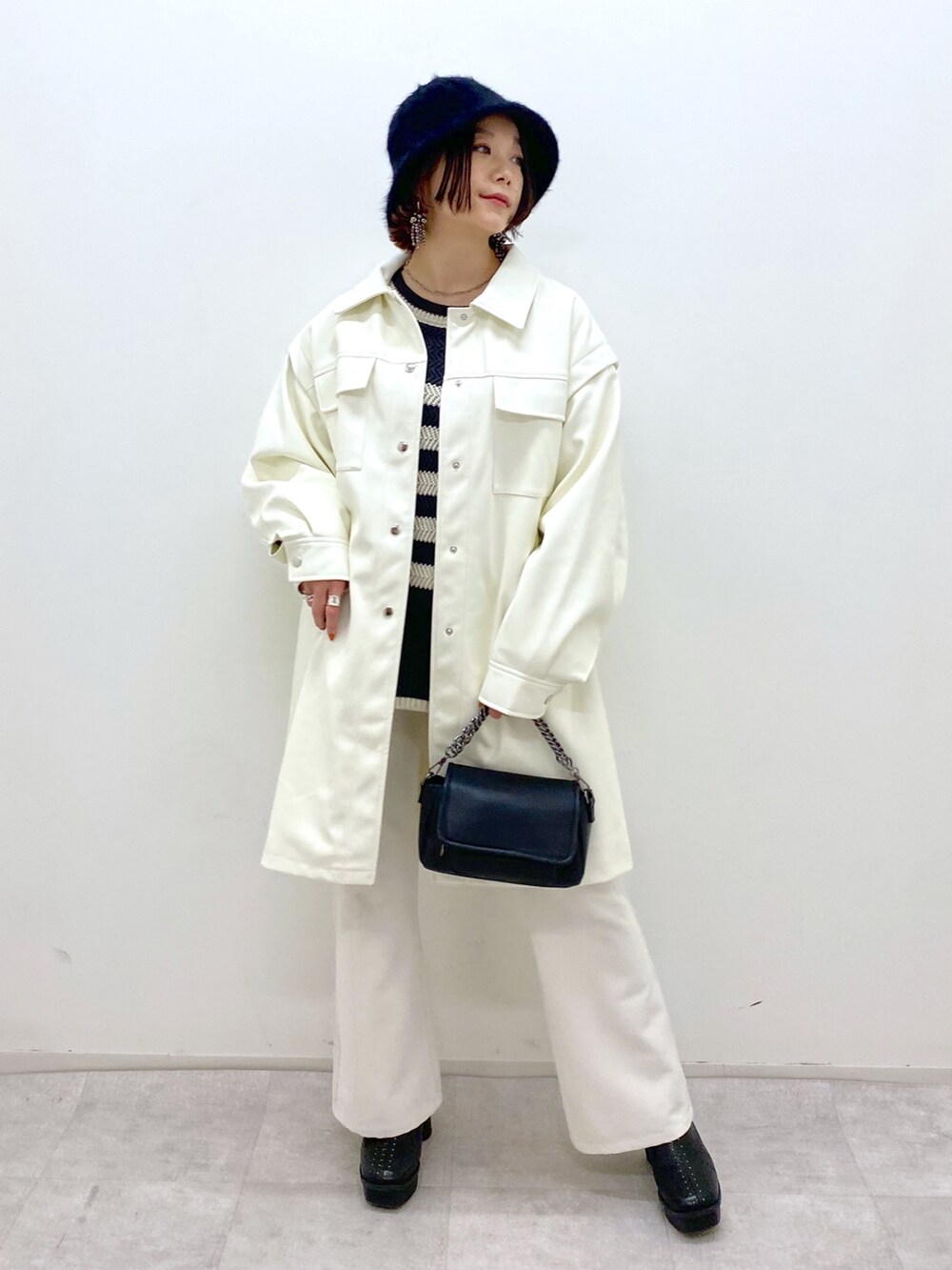 ホワイト系のジャケット/アウター、ブラック系のトップス、ホワイト系のパンツを着用したレディースの秋コーディネートの2枚目の写真